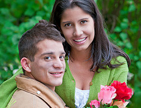 un pompier offrant un bouquet de fleur à une brunette