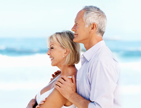 Couple âgé enlacé à la plage