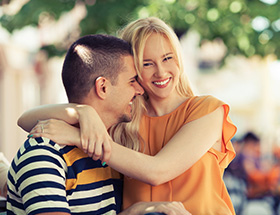 femme blonde souriante sur les genoux d'un homme