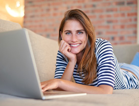femme souriante devant son ordinateur portable
