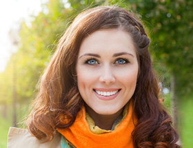 femme brune souriante, avec de grands yeux bleus